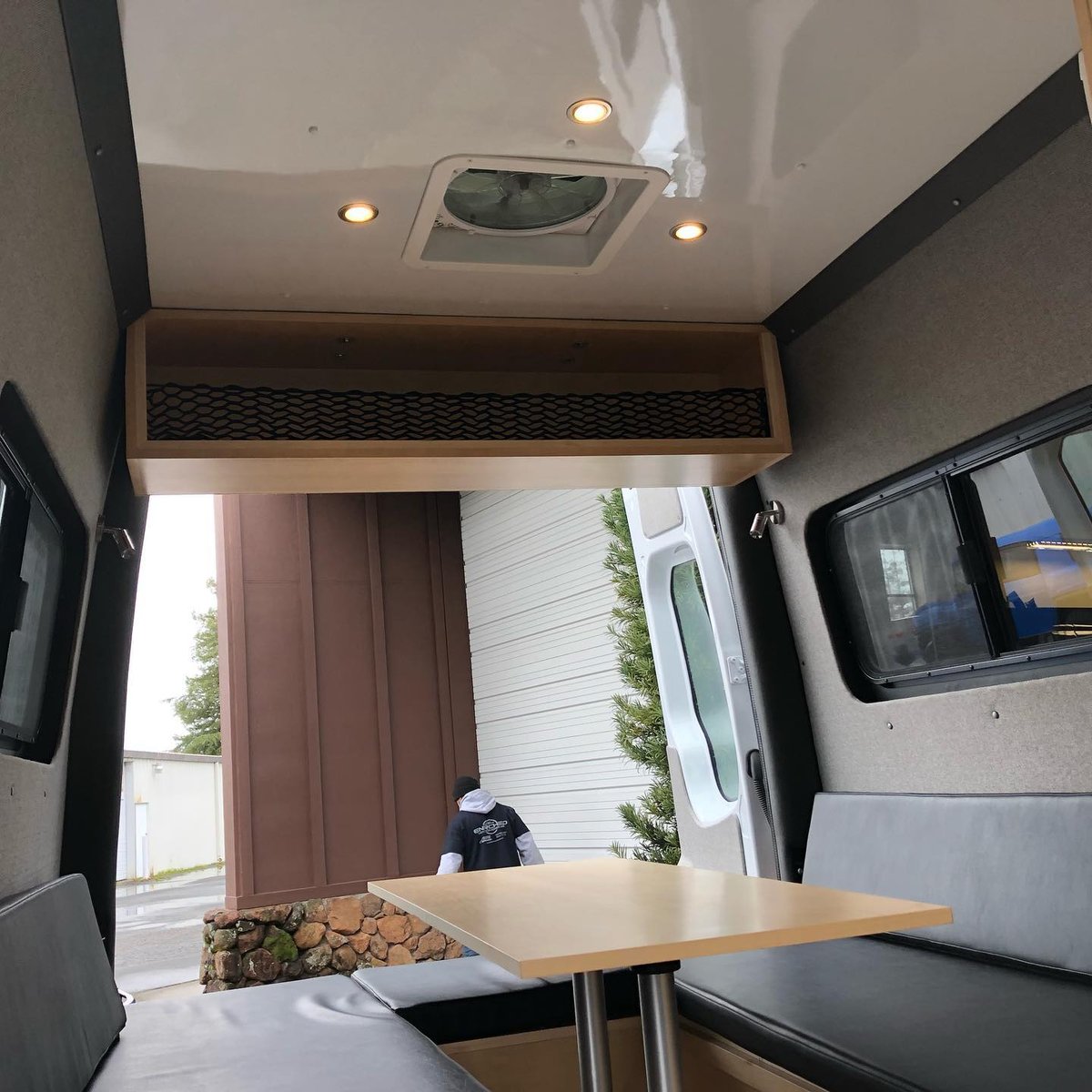 Finished van interior with a table and bench seating